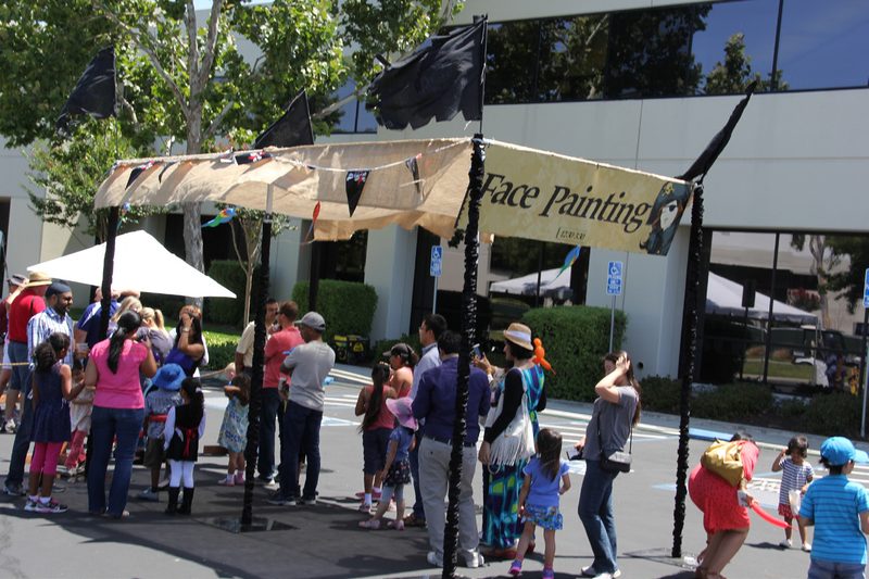 Face painting booth with families at an employee family day