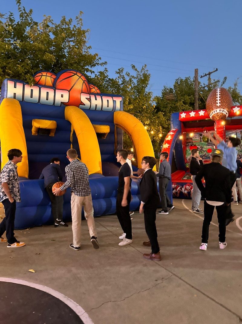 Guests shooting hoops at an inflatable Hoop Shot basketball game at a school carnival