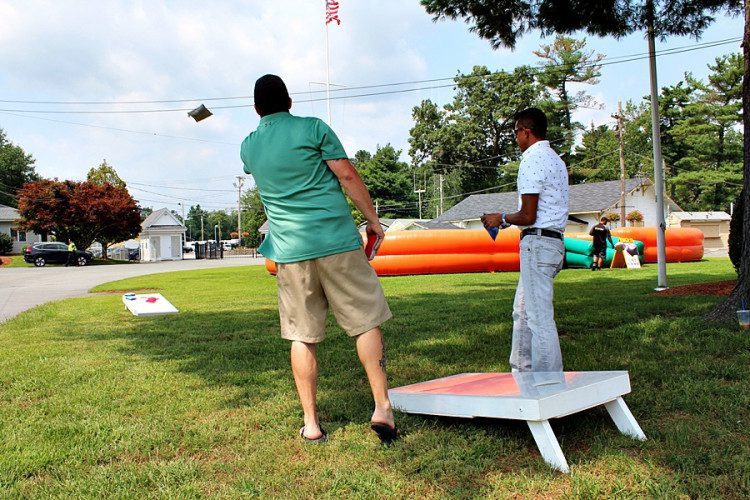 Coworkers playing cornhole yard games at a corporate event