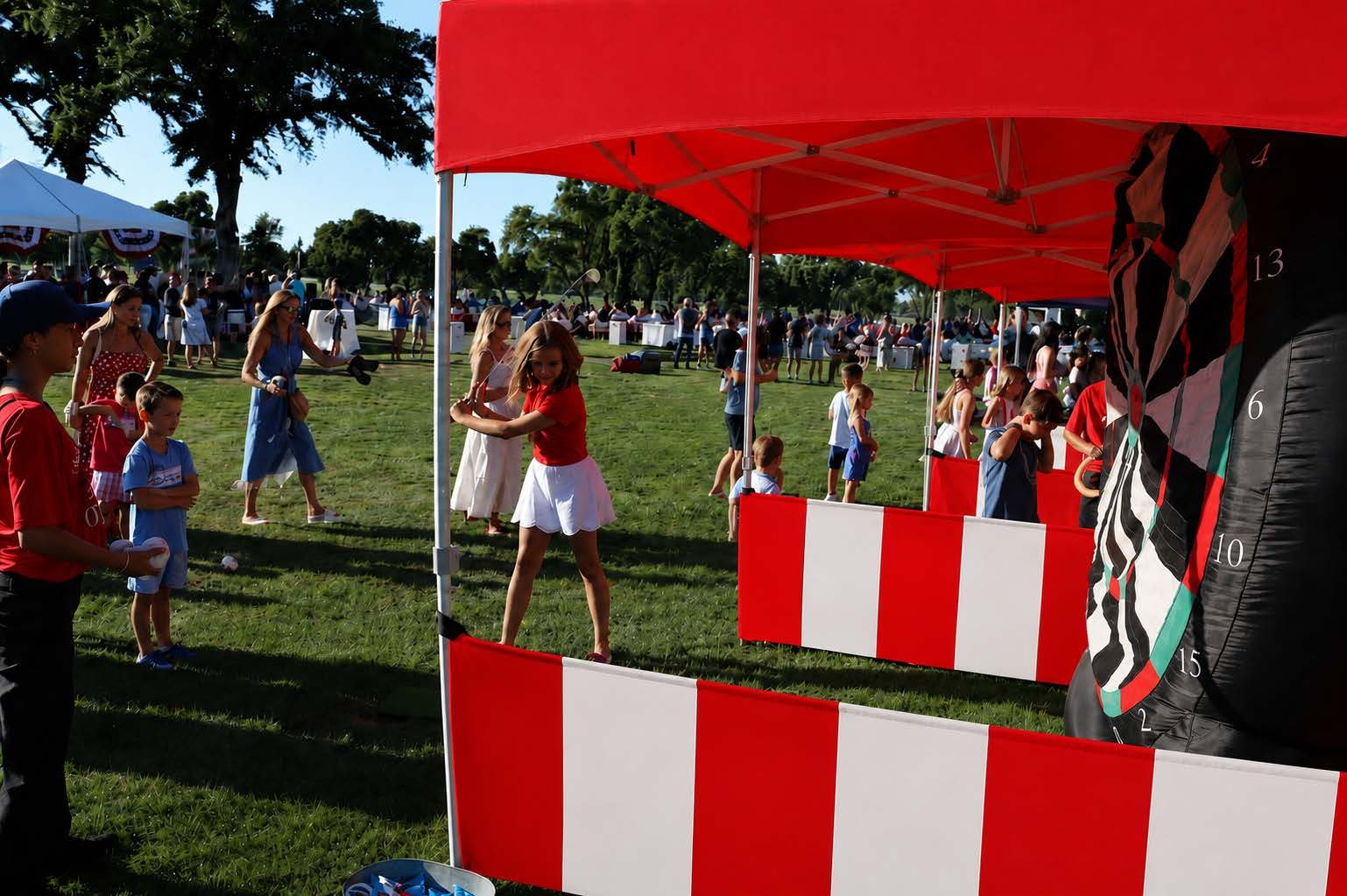Red and white striped carnival game booths at a school carnival in the Sacramento area