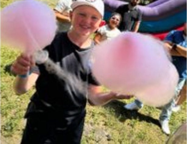 Guest holding fresh cotton candy at a fall festival