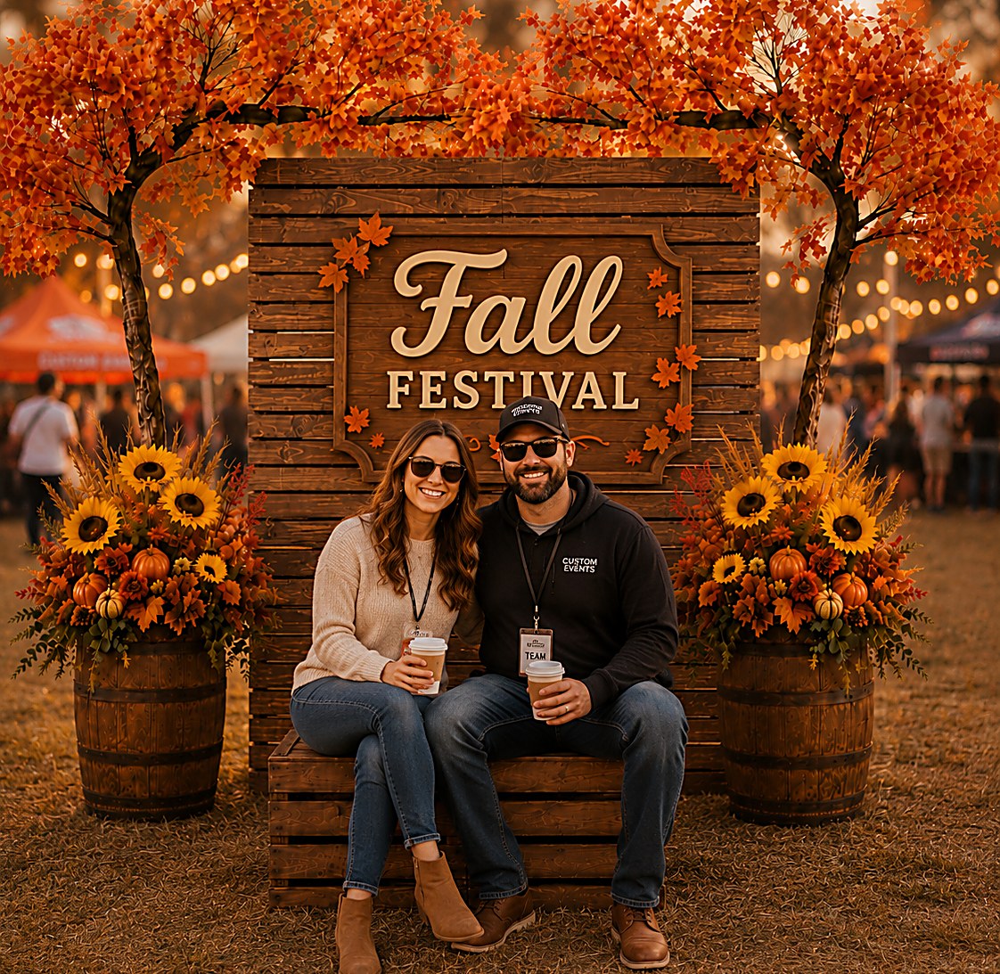 Couple at a Fall Festival photo booth backdrop with autumn trees and sunflowers
