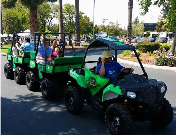 Guests riding a trackless train at an outdoor fall event in the Roseville area