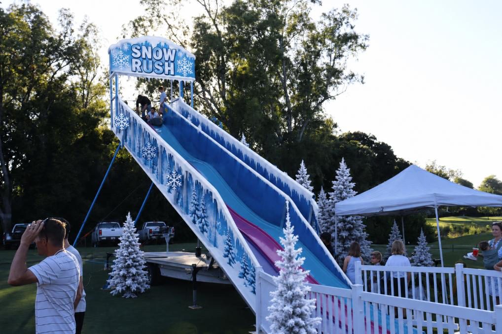 Guests riding the Snow Rush snow slide carnival ride at a Sacramento-area winter event