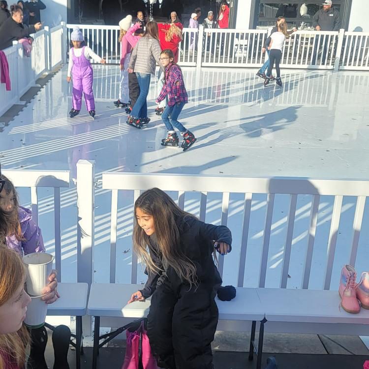 Guests skating on a synthetic ice rink rental at a Sacramento-area winter event